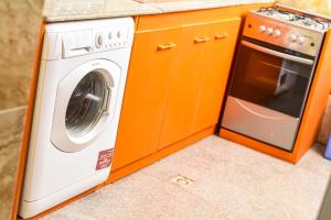 a kitchen with a washing machine and a microwave at Tunjor Homes in Barikin Jirga Summa