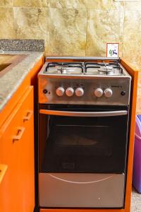 a stove in a kitchen with an orange oven at Tunjor Homes in Barikin Jirga Summa