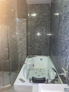 a bathroom with a bath tub and a shower at Tunjor Homes in Barikin Jirga Summa +9 photos