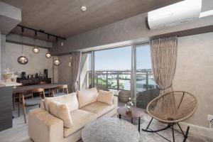 a living room with a couch and a table at JAPAVISTA Casa De Boss in Naha