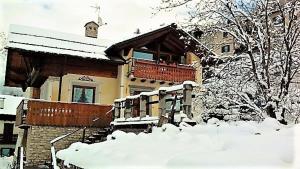a house with snow on the ground in front of it at Il Balcone Delle Alpi in Bormio