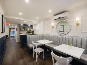 a restaurant with a bench and a table and chairs at voco The Franklin New York by IHG in New York
