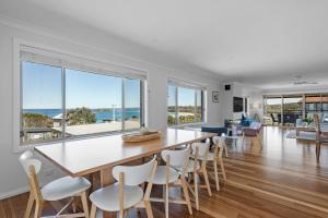 a dining room with a large table and chairs at Foredeck Views in Manyana