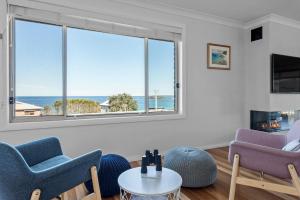 a living room with two chairs and a table at Foredeck Views in Manyana