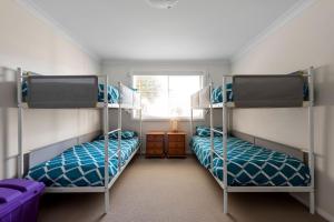 two bunk beds in a room with a window at Foredeck Views in Manyana