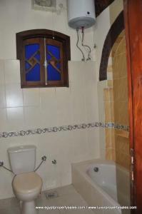 a bathroom with a toilet and a tub and a window at Healing House in Luxor +49 photos