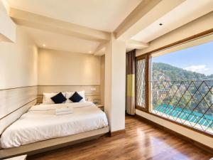 a bedroom with a bed and a large window at The Town Boho in Shimla