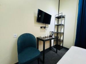 a room with a chair and a table and a tv at Backpackers Tashkent in Tashkent