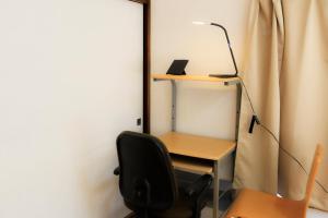 a desk with a lamp and a chair in a room at Mikansei Stay in Higashi-murayama