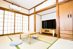 a living room with a table and a tv at Mikansei Stay in Higashi-murayama
