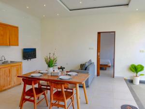 a kitchen and living room with a wooden table and chairs at Casagana by Gana Management Canggu in Dalung