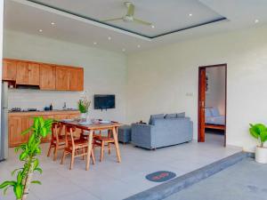 a kitchen and living room with a table and a couch at Casagana by Gana Management Canggu in Dalung