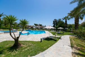 a resort with a swimming pool and palm trees at Eleni Village & Suites in Amoudara Herakliou