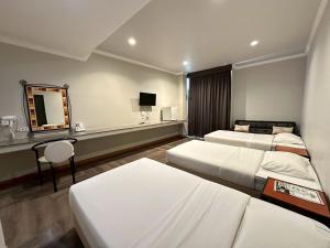 a hotel room with two beds and a mirror at Rattana View in Phitsanulok +66 photos