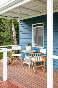 a patio with a table and chairs on a blue house at Suma Park Estate in Point Lonsdale