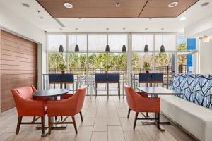 a lobby with tables and chairs and a couch at Holiday Inn Express - Bethlehem by IHG in Winder +65 photos