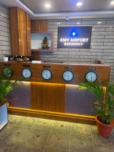 a waiting room with clocks on the wall at AMV Airport Residency in Bangalore