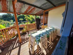 a wooden deck with a table and chairs on it at Grande Maison atypique proche du Maïdo in Saint-Paul