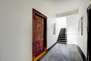a hallway with a wooden door and stairs at Super Collection O DLF CyberCity Hyderabad Formerly Key Suites in Kondapur +25 photos