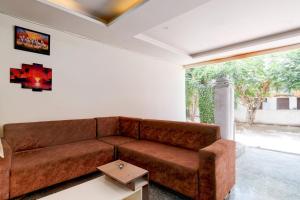 a living room with a brown couch and a table at Super Collection O DLF CyberCity Hyderabad Formerly Key Suites in Kondapur