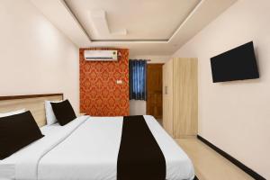 a bedroom with a large bed and a tv at Super Hotel O Gorakhpur Railway Junction Road Golghar Formerly RR Inn in Gorakhpur