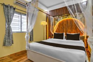 a bedroom with a large bed with a canopy at Hotel O Bangur Kolkata Formerly The Avenue Inn in Nager Bazaar