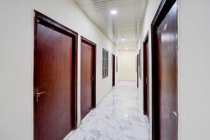 a hallway with wooden doors and marble floors at OYO Collection O Govind Vihar Matiyari Formerly Saffron in Lucknow +23 photos