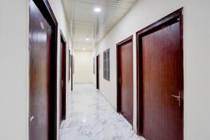 an empty corridor with doors and a tile floor at OYO Collection O Govind Vihar Matiyari Formerly Saffron in Lucknow