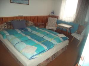 1 dormitorio con 1 cama grande con sábanas y sillas azules en Benecko 131, en Benecko