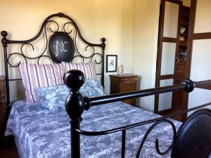 - une chambre dotée d'un lit avec un cadre noir dans l'établissement Agriturismo La Palazzina, à Palaia
