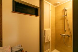 a bathroom with a shower with a glass door at はやちねの宿ラビット in Hanamaki