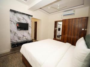 a bedroom with a white bed and a marble wall at AMV Airport Residency in Bangalore +7 photos
