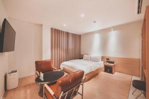 a hotel room with a bed and a table and chair at 호텔 인썸니아 Hotel Insomnia 失眠酒店 in Daegu