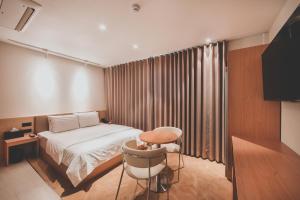a bedroom with a bed and a table and a chair at 호텔 인썸니아 Hotel Insomnia 失眠酒店 in Daegu