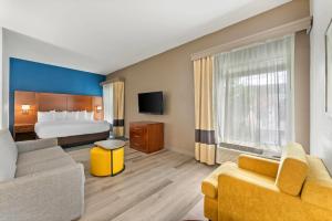 a hotel room with a bed and a couch at Comfort Suites Bethlehem Near Lehigh University and LVI Airport in Bethlehem