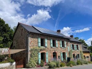 a brick house with a solar roof on a street at Fleurs de lin in Saint-Brieuc-des-Iffs