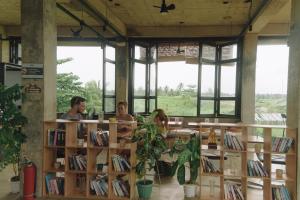 eine Gruppe von Menschen sitzt in einer Bibliothek in der Unterkunft Lungga in General Luna