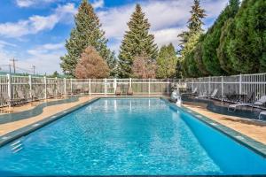 a swimming pool with a fence and trees at Quality Inn Rock Springs - Green River in Rock Springs