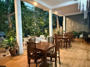 a dining room with tables and chairs on a patio at Lake Wave Hotel in Anuradhapura