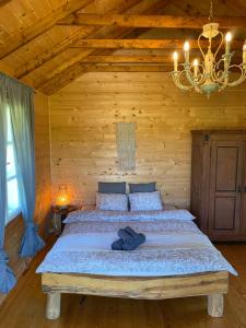 a bedroom with a bed in a wooden room at Cozy chalet for nature lovers in Ķevele