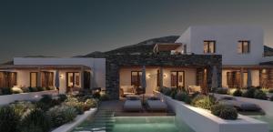 a villa with a swimming pool at night at Parian Chronicle Hotel Paros, Destination by Hyatt in Kampos Paros