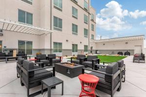 a patio with tables and chairs and a fire pit at MainStay Suites Carlsbad South in Carlsbad