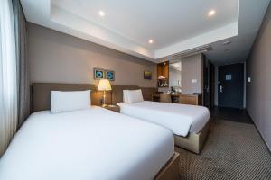 a hotel room with two beds and a desk at Busan Business Hotel in Busan +73 photos