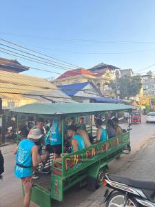 a group of people riding in a trolley train at The Funky Village in Siem Reap