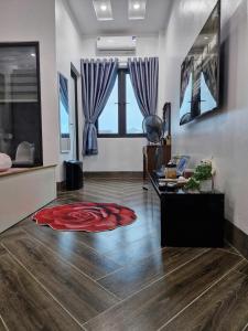 a living room with a red rug on the floor at Home Phong Vân in Hâu Thon +3 photos