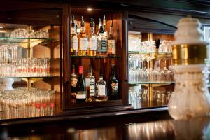 a bar with many bottles and glasses of alcohol at The Ascot Hotel in Cologne