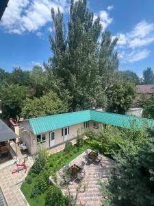 an aerial view of a house with a green roof at Dosman Hotel Bishkek in Bishkek