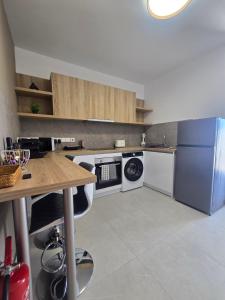 a kitchen with a refrigerator and a table with a dishwasher at Divina Loft C Modern Loft with Shared Pool in Perivolia