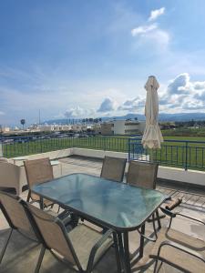 a patio with a table and chairs and an umbrella at G&E Harbour Apartments in Lachi