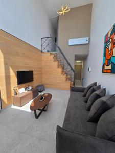a living room with a couch and a staircase at Divina Loft C Modern Loft with Shared Pool in Perivolia